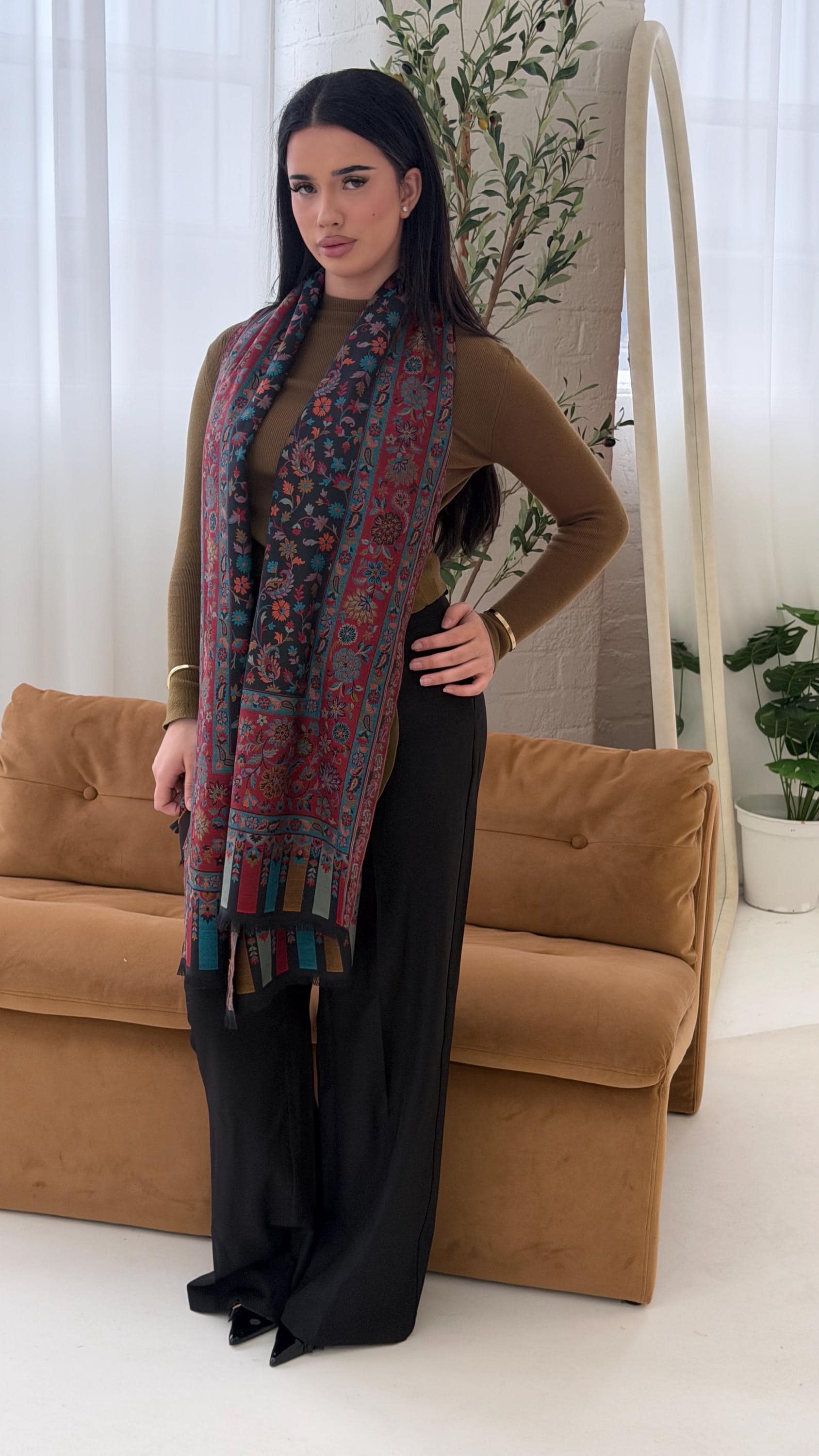 Woman wearing a patterned scarf in a living room setting