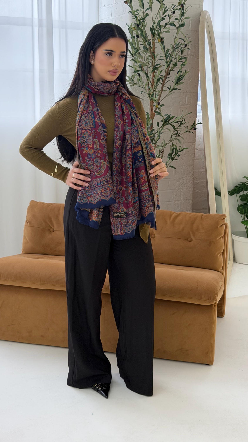 Woman wearing a blue patterned pashmina shawl scarf  in a living room setting