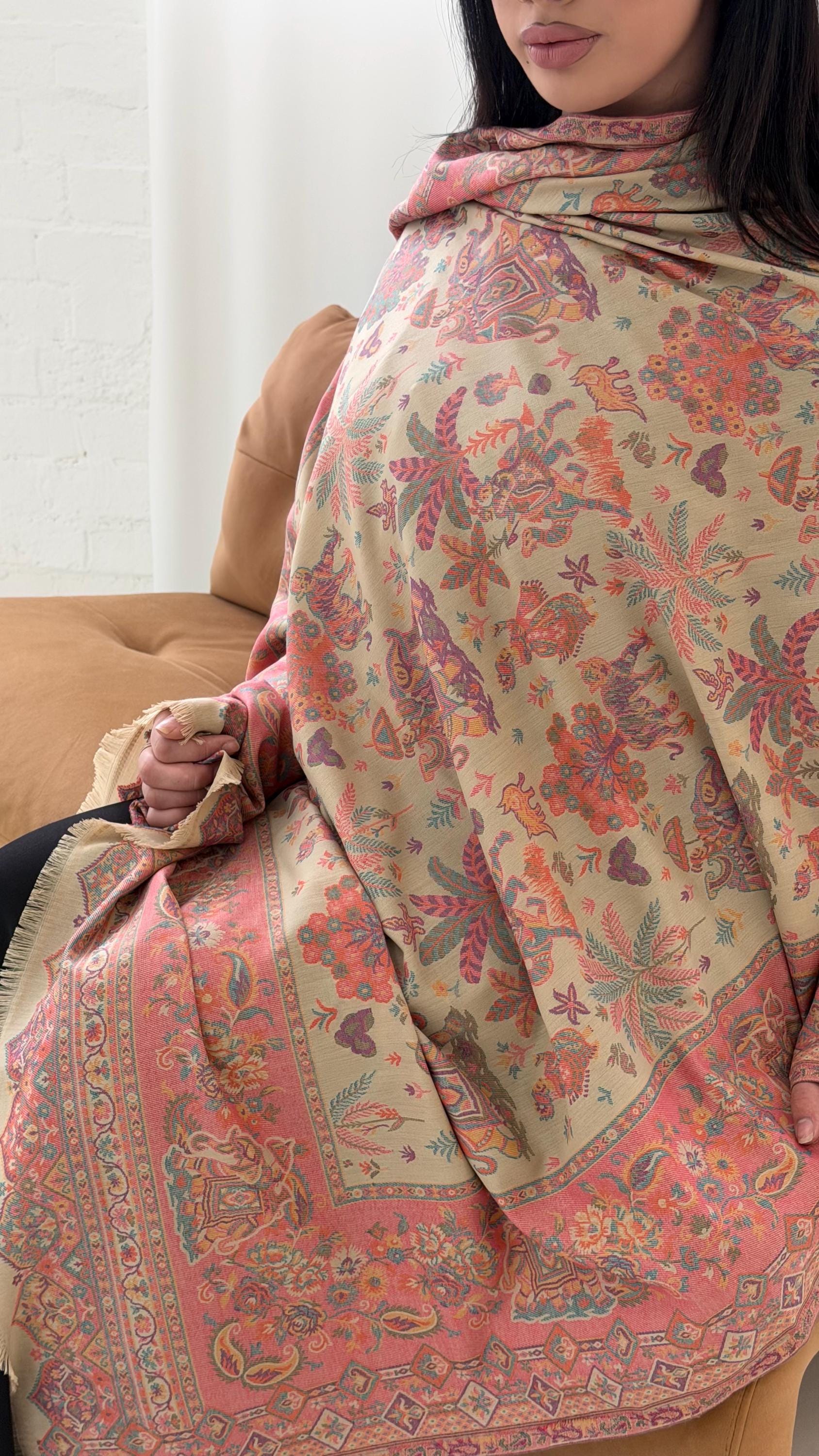 Woman wearing a beige patterned pashmina shawl with a neutral background