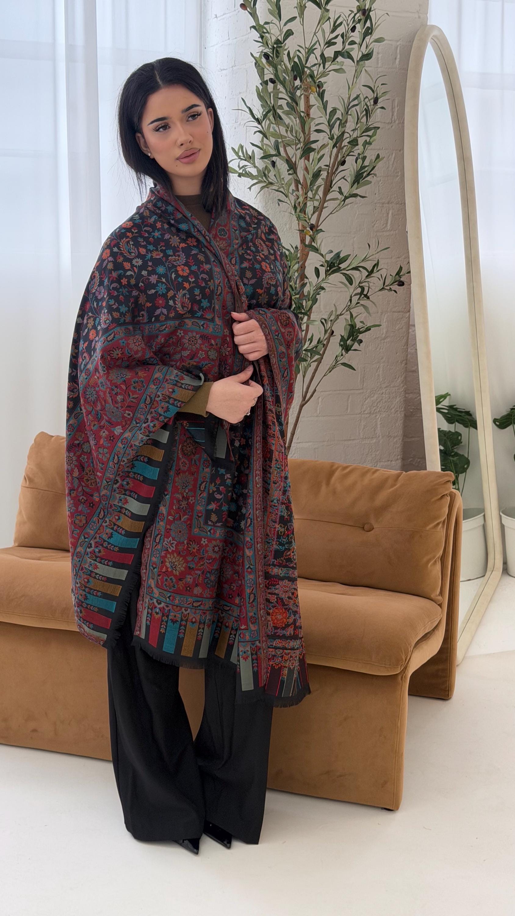 Woman holding a patterned scarf in a living room setting