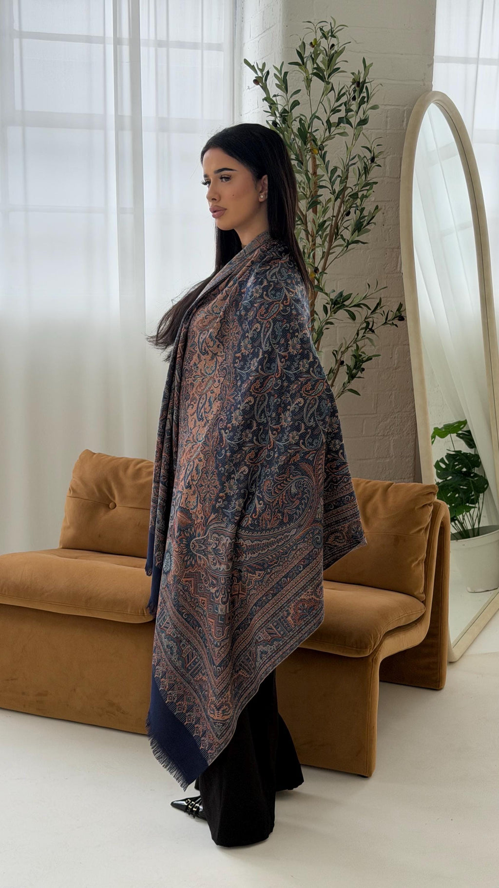 Woman holding a blue scarf in a living room setting
