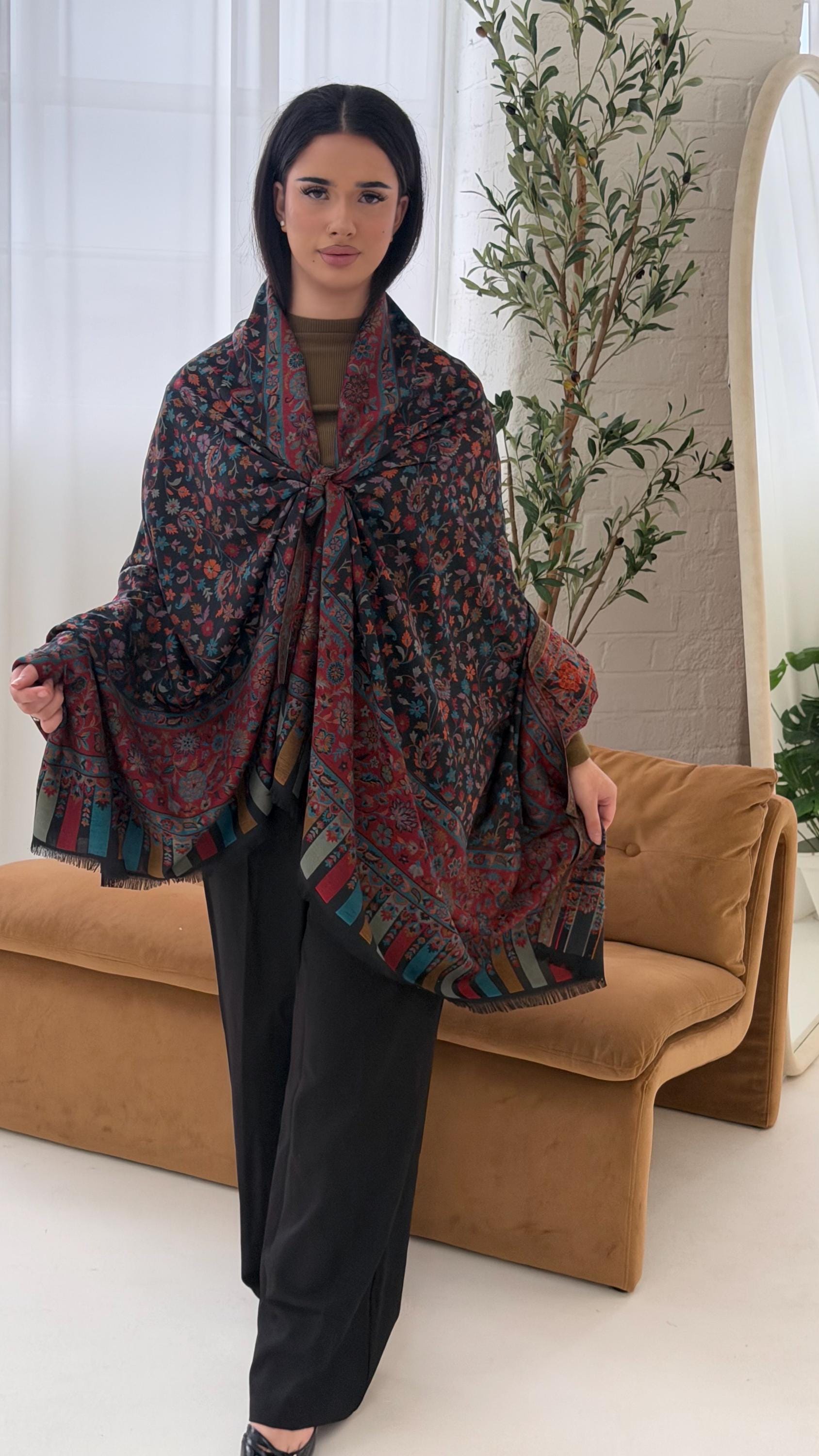 Woman wearing a patterned shawl in a living room setting